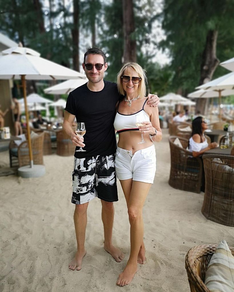 Carol McGiffin in a white bikini and shorts while her husband wears black swim shorts