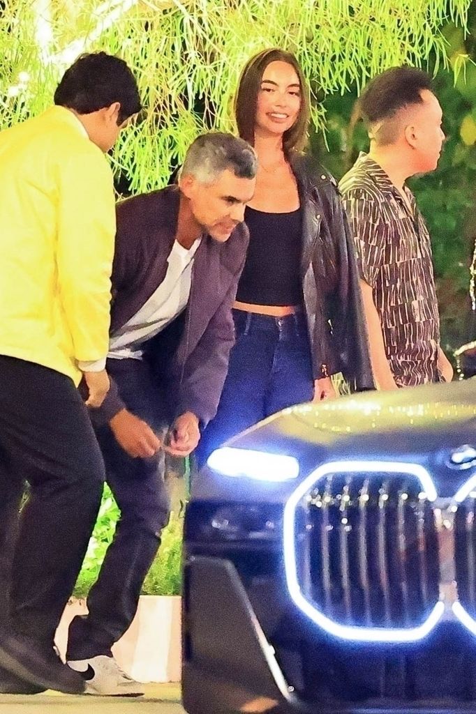 cash warren and hana sun doerr standing by bmw