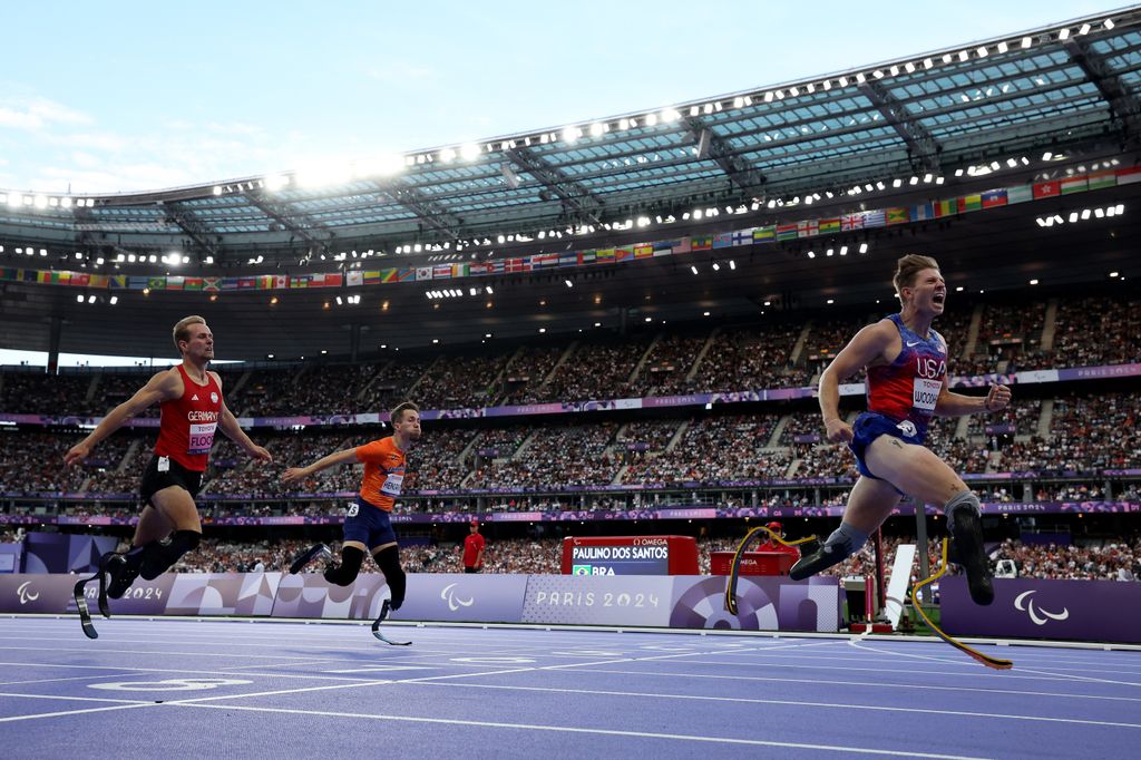 Hunter Woodhall of Team United States (R) crosses the finish line ahead of Johannes Floors of Team Germany (L) and Olivier Hendricks of Team Netherlands (C) during the Men's Para Athletics 400m T62 Final Race