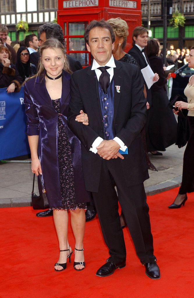 Sydney Stevenson in a purple floral dress with Robert Lindsay in a suit