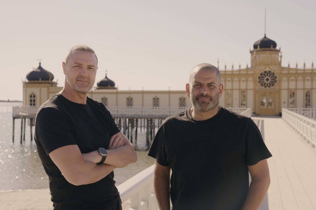 TX DATE:29-09-2024,TX WEEK:40,EMBARGOED UNTIL:24-09-2024,DESCRIPTION:Paddy and Chris in front of Varberg Sauna where they joined a group of retired, Swedish sauna-goers.,COPYRIGHT:BBC Studios,CREDIT LINE:BBC/BBC Studios