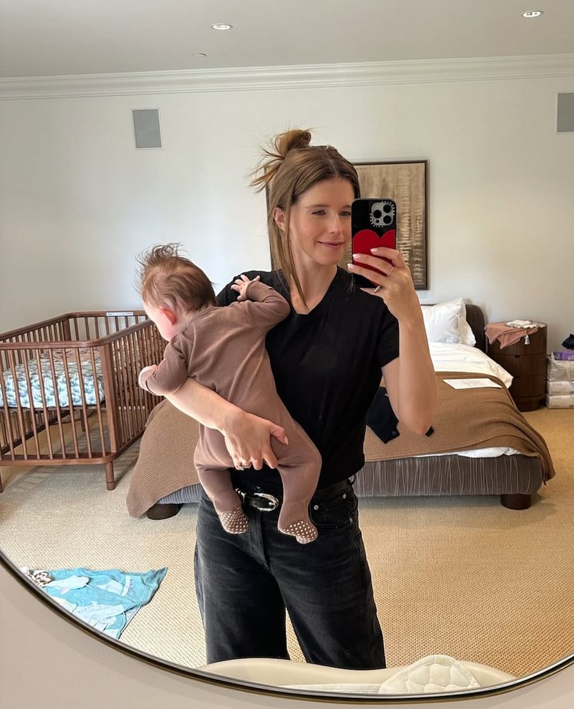 Mirror selfie of Katherine cradling her baby