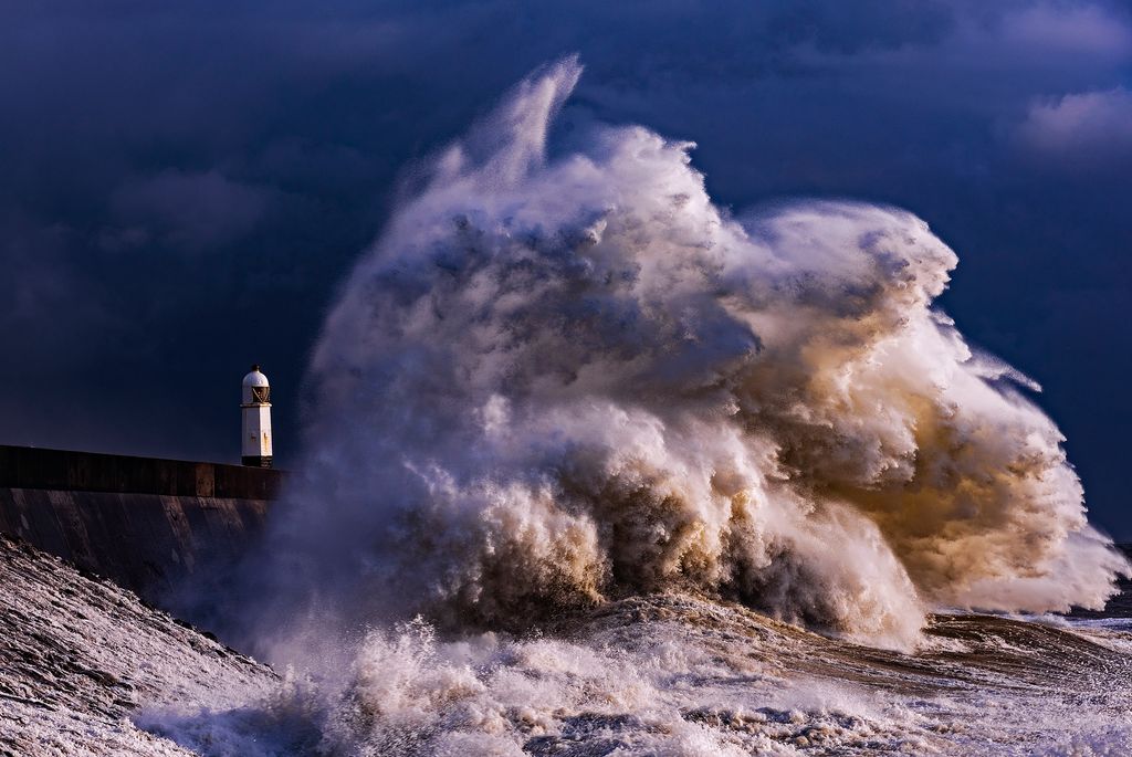Large wave hitting a lighthouse