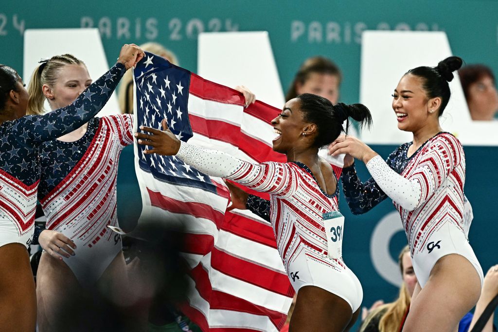 US' Simone Biles (C) and teammates celebrate after team USA won the artistic gymnastics women's team final during the Paris 2024 Olympic Games 