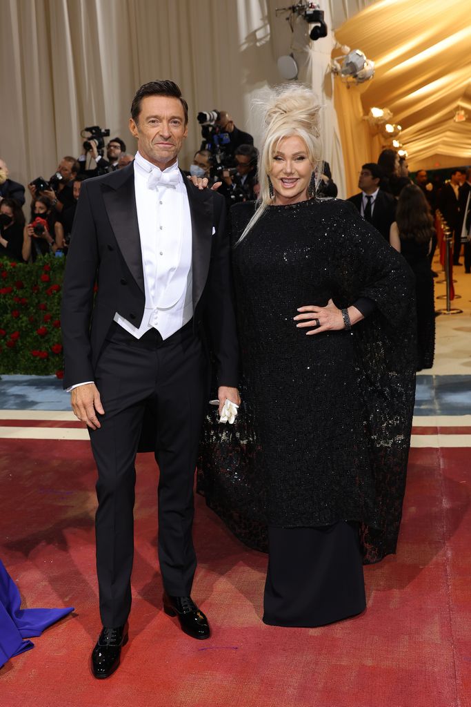 Hugh Jackman in a suit and white waistcoat with wife Deborra-Lee in a sparkly dress