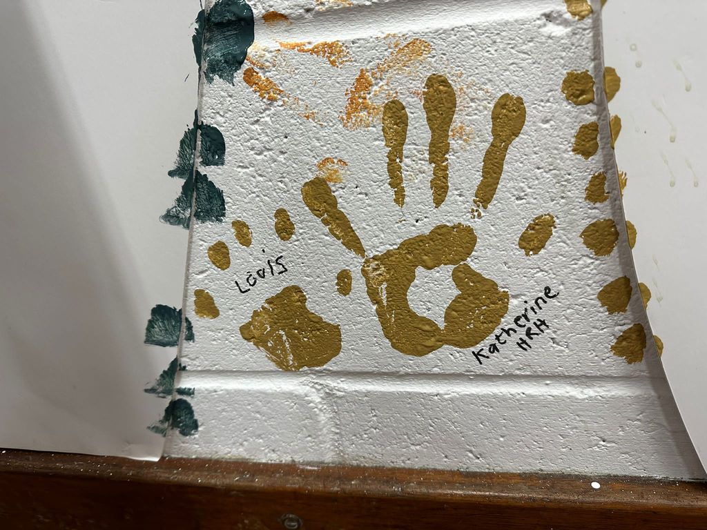 Kate and Louis' handprints are together on the Scout  hut wall