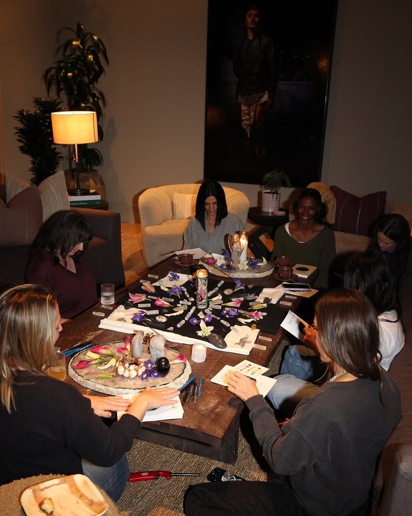 Kerry Washington's friend sit on the floor around a table as they set intentions