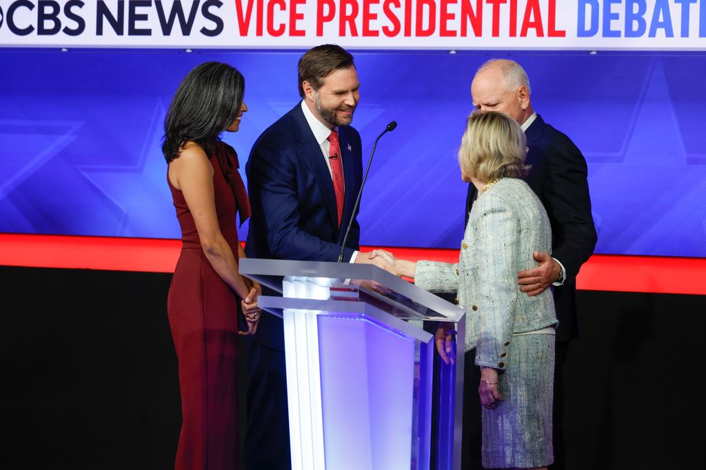 Kandidat Wakil Presiden dari Partai Demokrat Gubernur Minnesota Tim Walz dan istrinya Gwen Walz (kanan) berbicara dengan Senator Kandidat Wakil Presiden dari Partai Republik J.D. Vance (kanan) dan istrinya Usha Vance setelah debat 