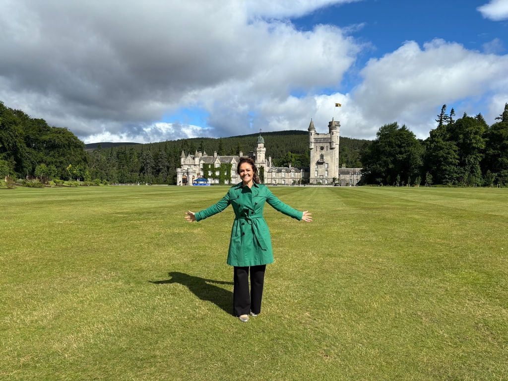 Emily Nash standing in a field in front of Balmoral Castle