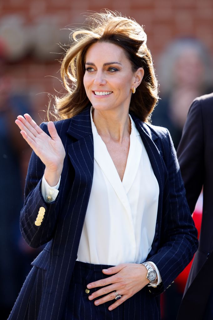 Catherine waving in white shirt and navy blazer