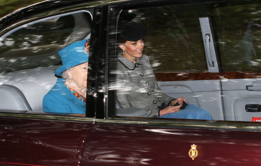 Queen Elizabeth II and Kate Middleton sit under a blue blanket in car