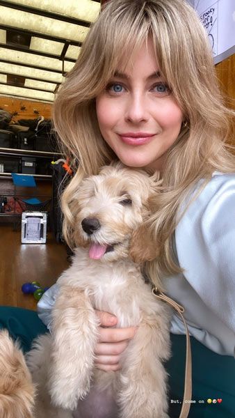Julianne Hough smiles with one of the golden puppies 