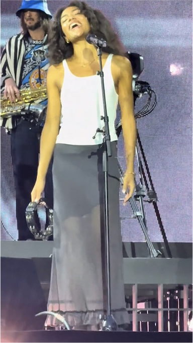 Olivia Dean performing on stage in sheer Mia skirt by No Emotions