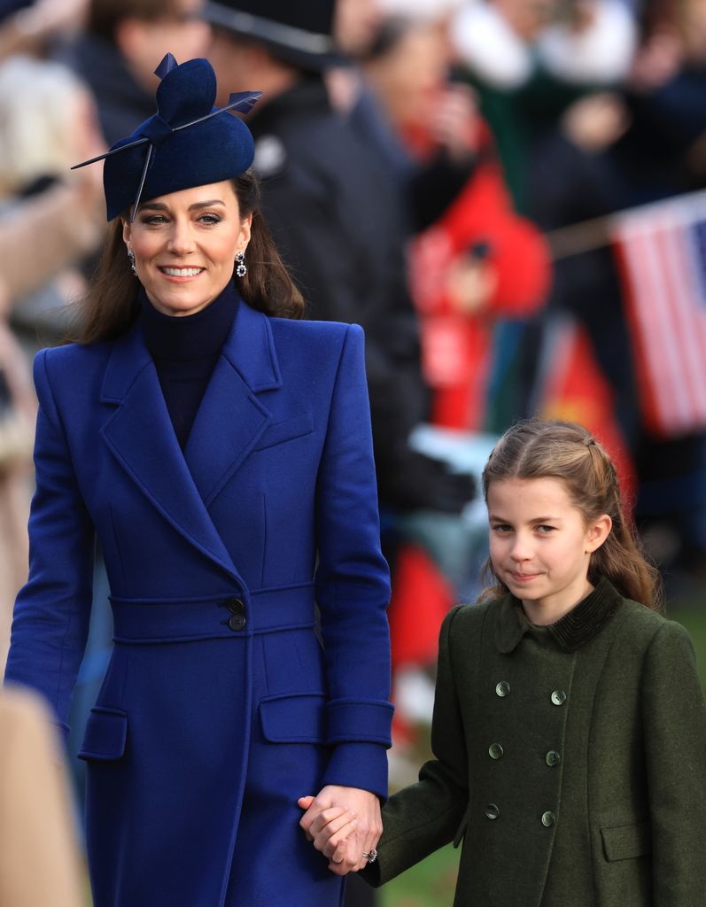 Catherine, Princess of Wales and Princess Charlotte in coats walking hand in hand