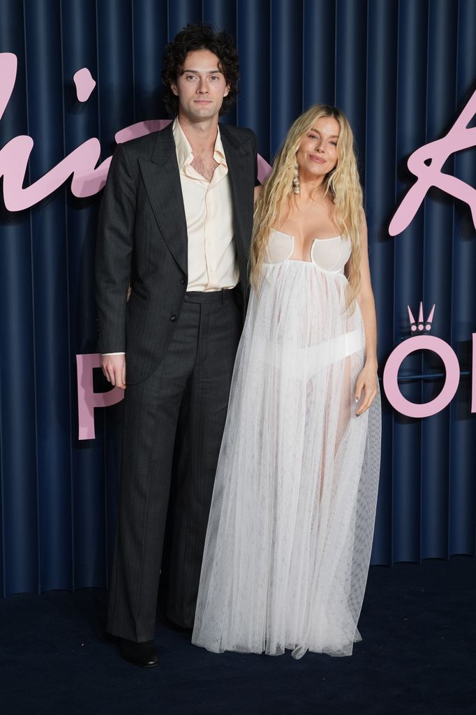 Oli Green and Sienna Miller pose on the carpet at Fashion Awards