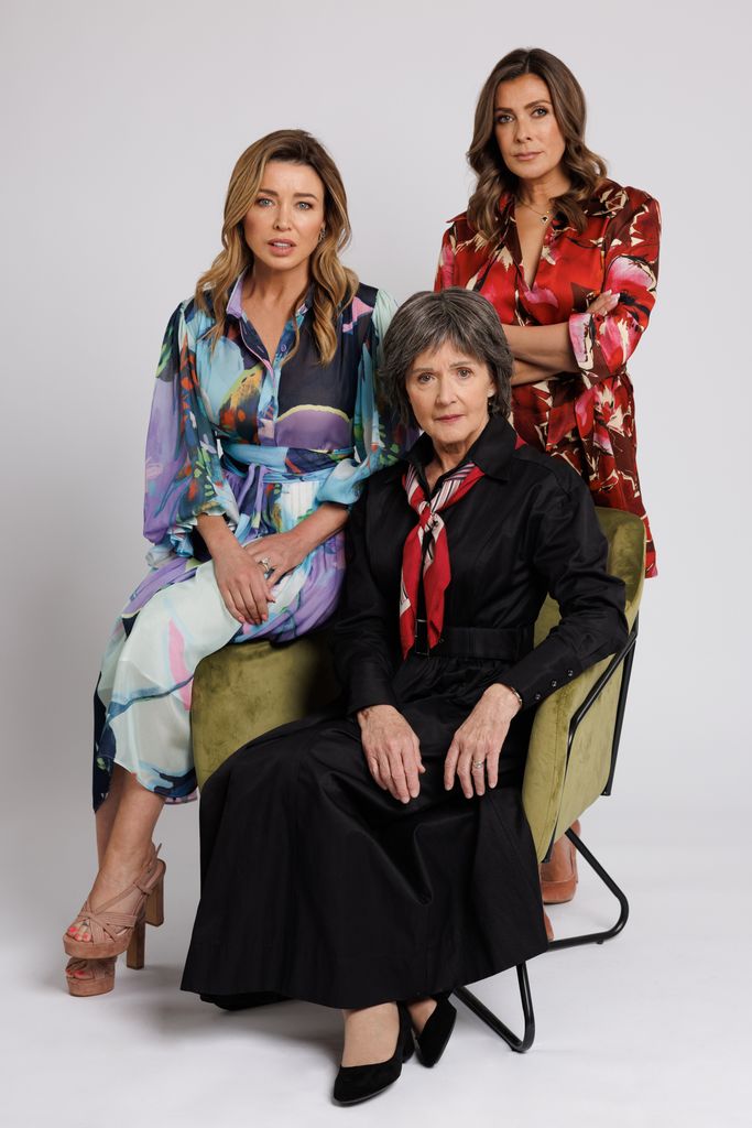 three women posing for photo against white background