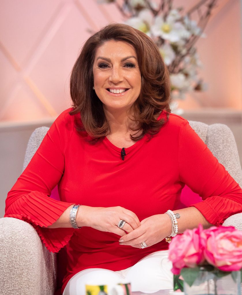 Jane McDonald in a red jumper and white trousers