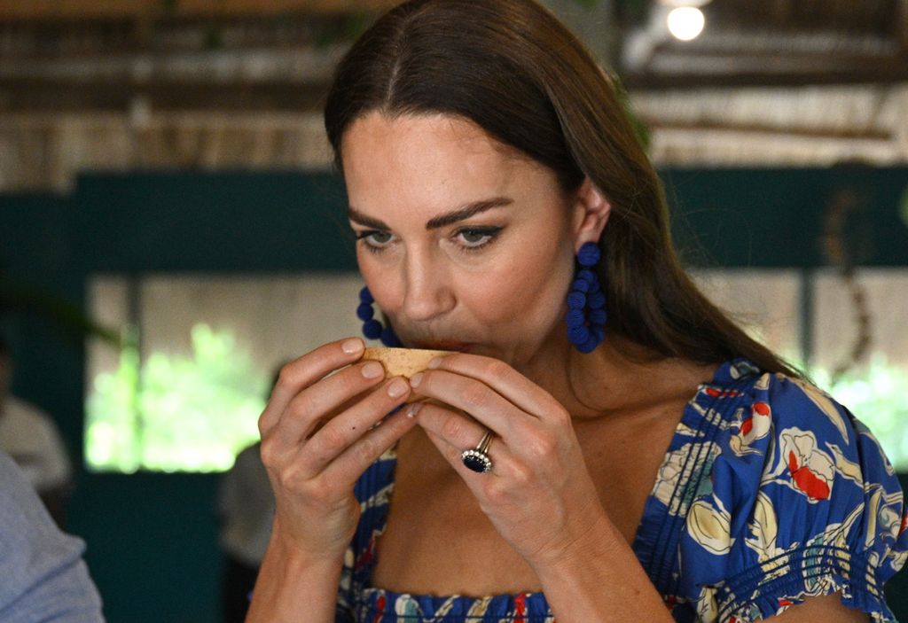Princess Kate in a blue dress eating food