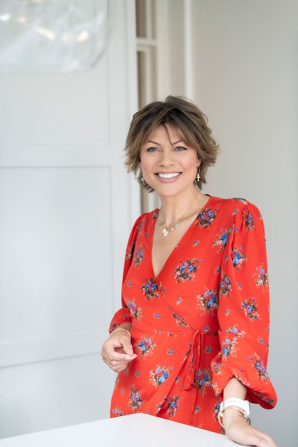 Kate Silverton smiling. She is wearing a red floral dress
