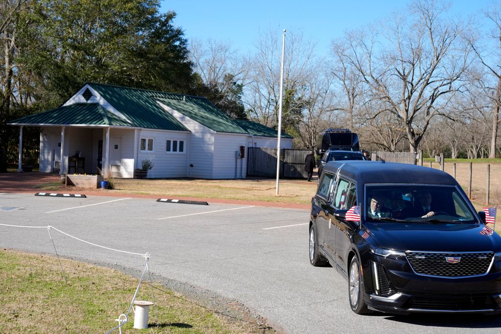 The hearse containing the casket of former US President Jimmy Carter pauses at the Jimmy Carter Boyhood Farm in Archery, Georgia