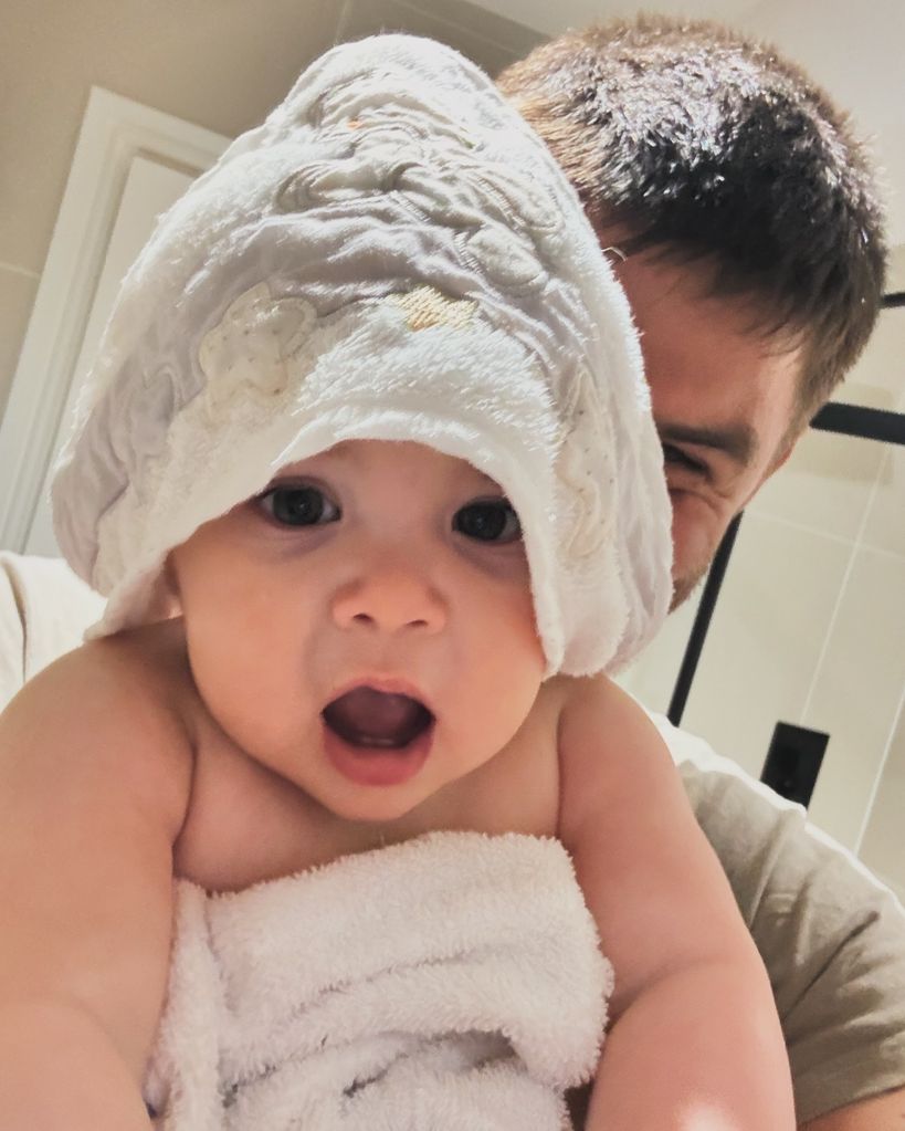 father holding daughter wrapped in towel 