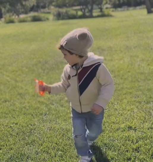 Archie flying a kite in Montecito, wearing jeans and bobble hat