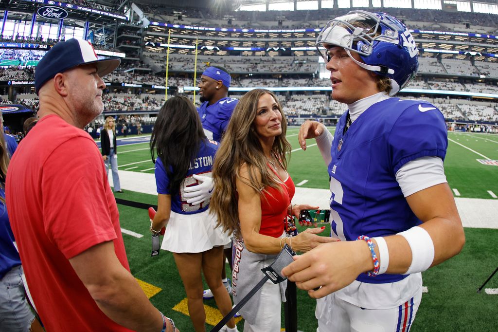 Jaxson Dart #6 of the New York Giants speaks with his parents during pregame warm ups prior to the game against the Dallas Cowboys at AT&T Stadium on September 14, 2025 in Arlington, Texas
