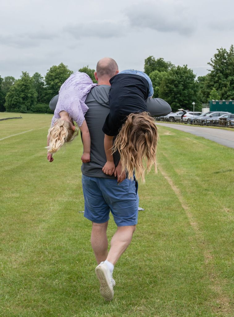Mike Tindall playfully carries his two daughters
