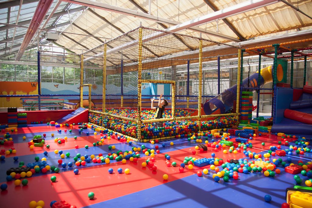 Boy having fun at indoors playground, playing with multi colored balls