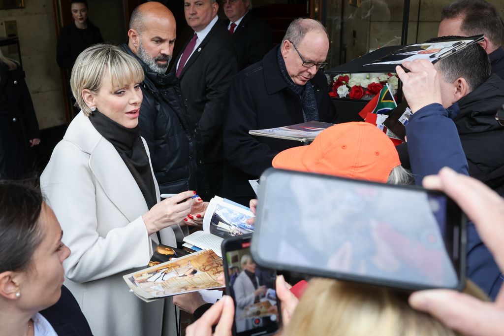 The royal couple signing autographs