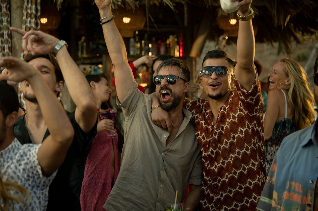 two men with hands in air at party 