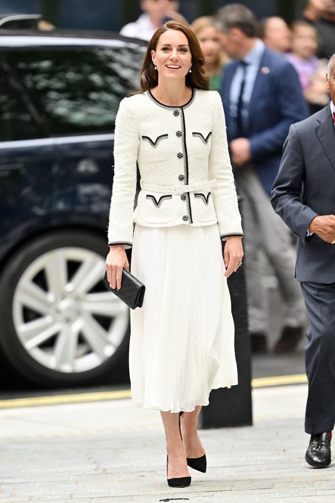 Catherine in white blazer and skirt with black piping