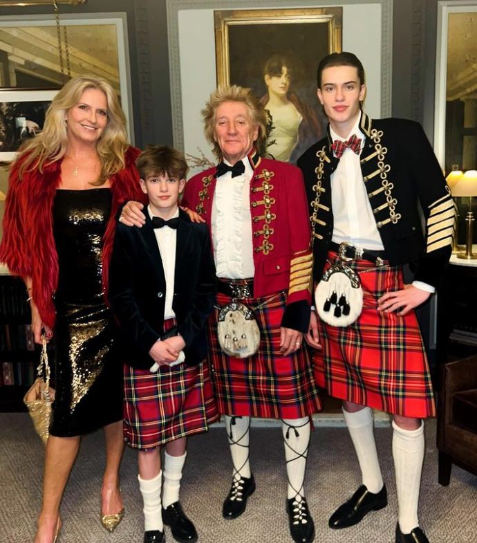 Penny Lancaster standing with Aiden Stewart, Rod Stewart and Alastair Stewart with the men in kilts