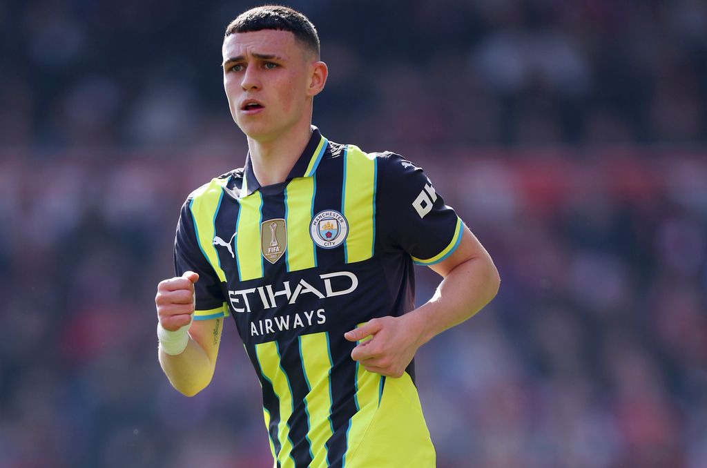 Phil Foden playing football in a black and yellow striped kit