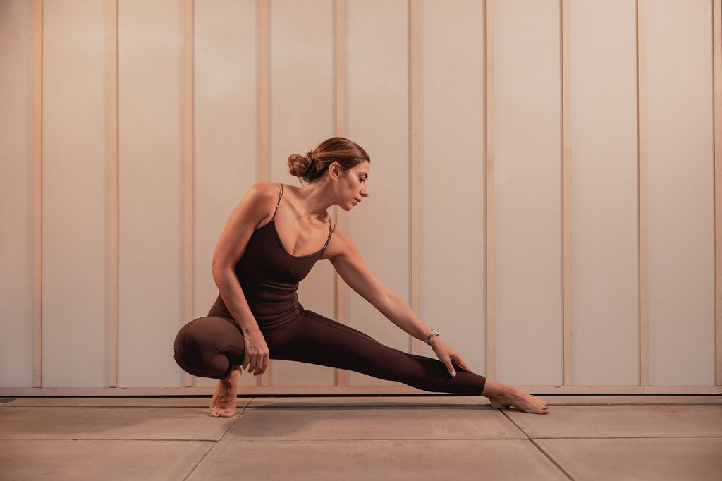 Woman in brown activewear stretching 