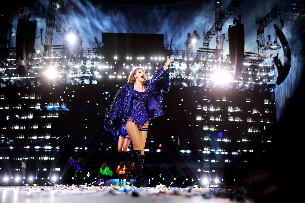 Taylor Swift on stage in a midnight blue bodysuit