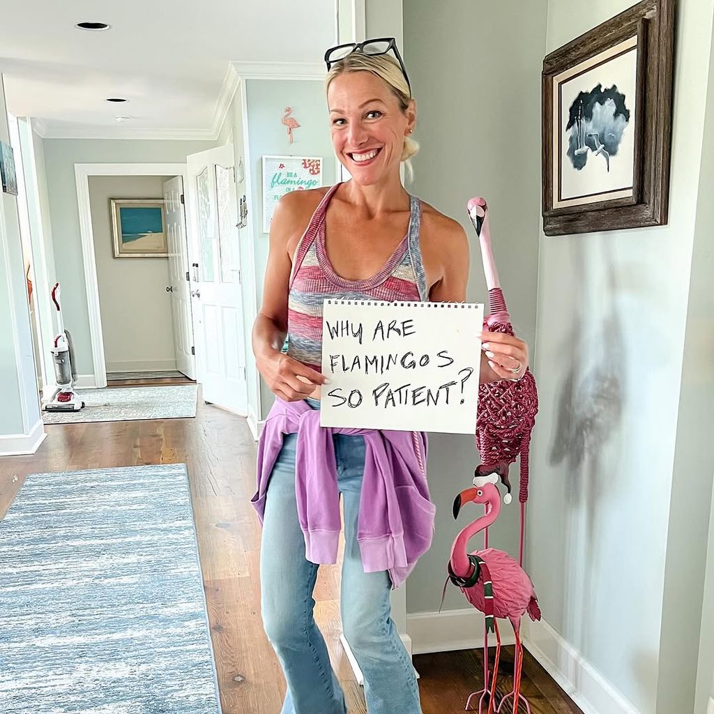 Craig Melvin's wife Lindsay holds a sign in their home