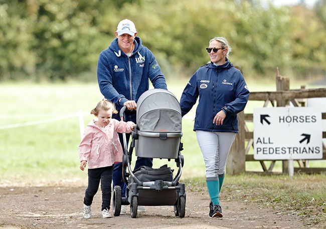Zara and Mike Tindall walking with their daughter Mia and pushing Lena in her pram