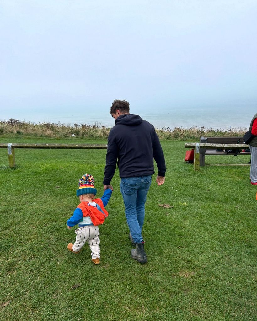 father holding hands with little boy 