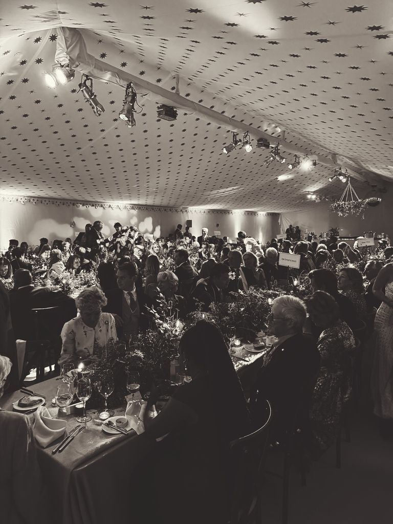 black and white photo of people at dining tables at wedding reception