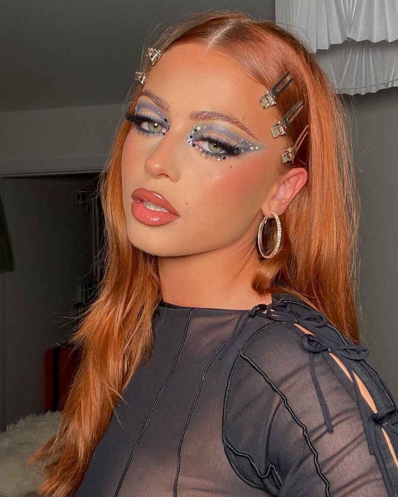 Woman with dark eye makeup with silver and black gems 