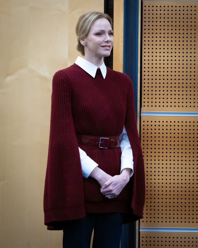 Princess Charlene in a burgundy cape smiling