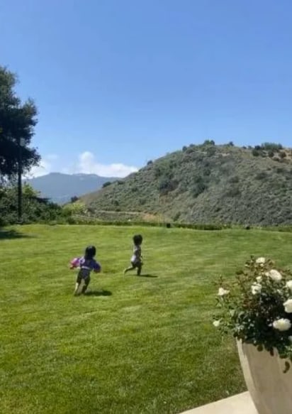 Kylie's two children running across the garden