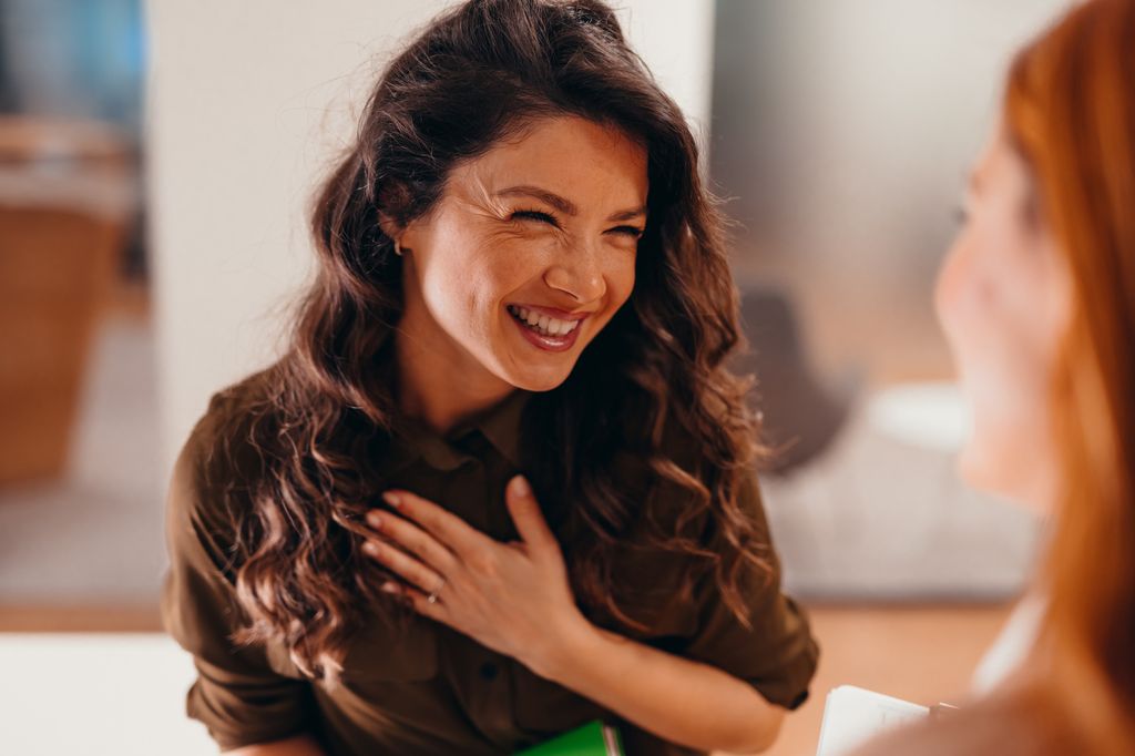 femme souriante avec la main sur le coeur 