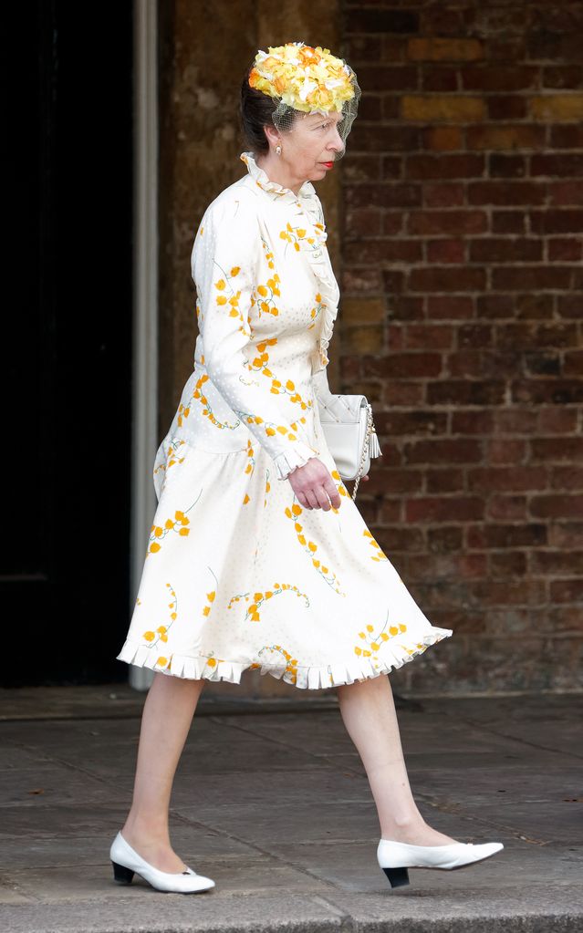 Princess Anne walking in a white dress with yellow florals
