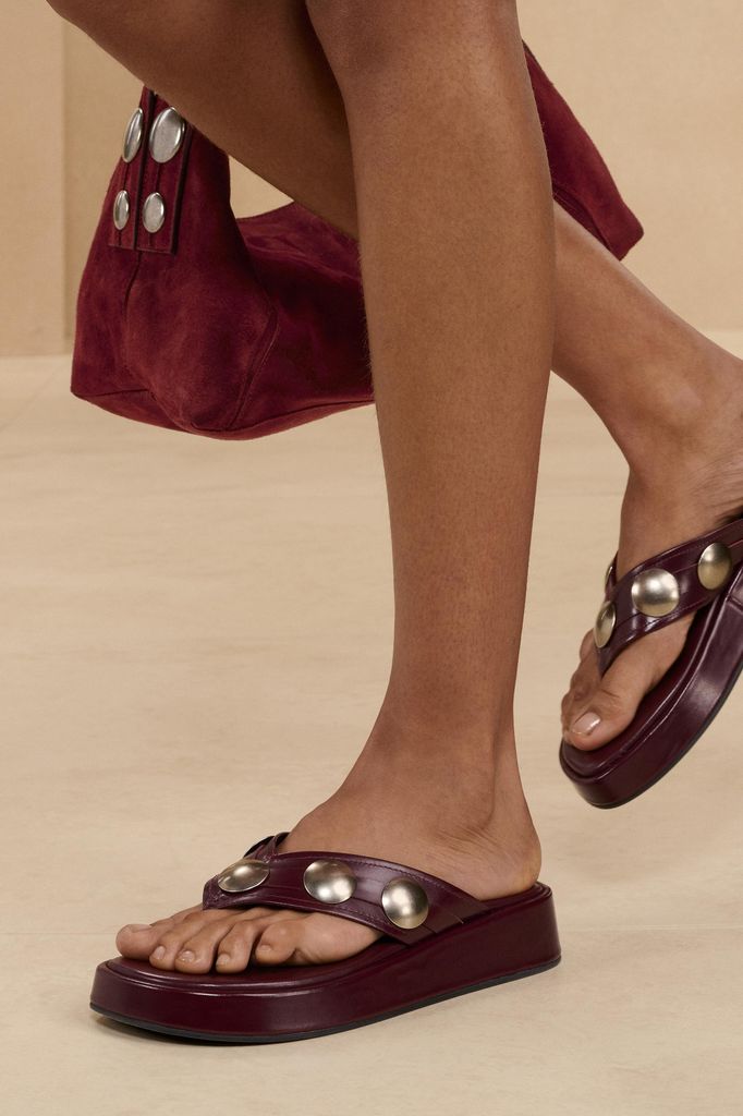 A model wears a pair of leather sandals
