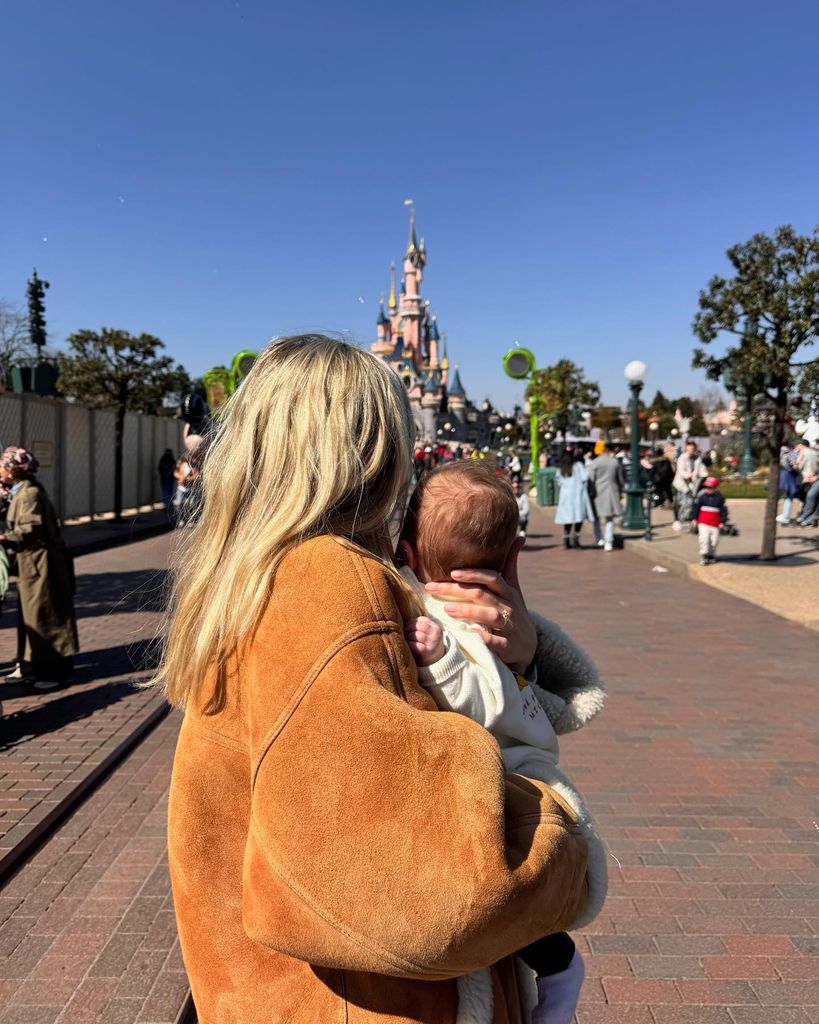 mollie from behind holding baby in disneyland paris
