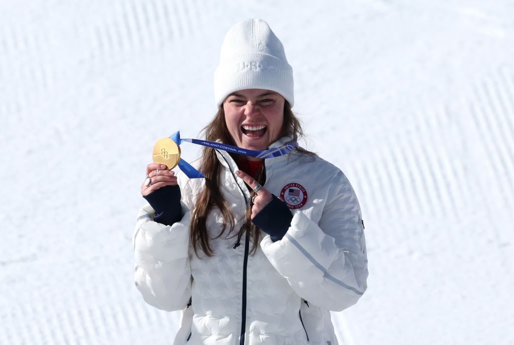Breezy Johnson, médaillée d'or de l'équipe des États-Unis, célèbre sur le podium lors de la cérémonie de remise des médailles de la descente féminine le deuxième jour des Jeux olympiques d'hiver de Milan Cortina 2026 au centre de ski alpin de Tofane, le 8 février 2026 à Cortina d'Ampezzo, en Italie.