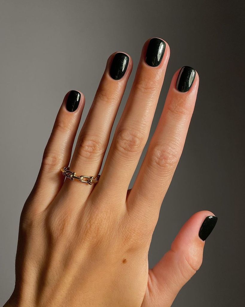 Glossy Black: Short, rounded nails painted in a solid, glossy black. This manicure offers a sleek and minimalist style that’s effortlessly chic and versatile for any occasion.