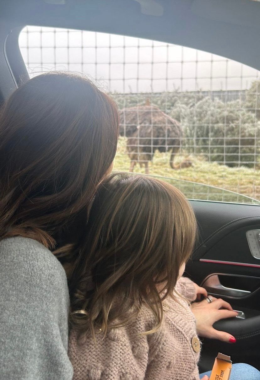 Alex Jones in a car with her daughter Annie, looking at an ostrich